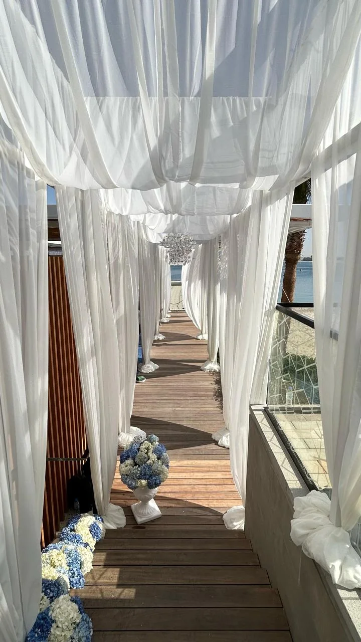 White draped walkway with chandeliers