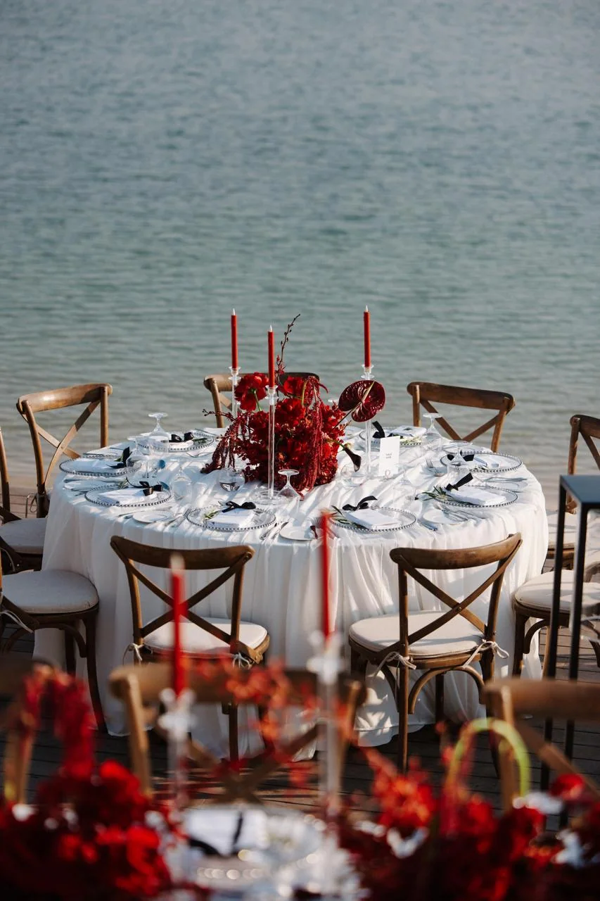 Waterfront place settings and red flowers